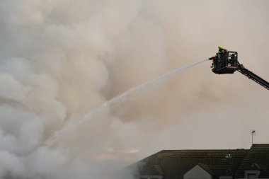 İtfaiyecilerle turnalar patladı. İtfaiyeci adam geri çekilebilir vinç. Yüksekten alevi söndürüyor. İtfaiyeci yangını söndürür. İtfaiye hortumunu binaya yöneltti.