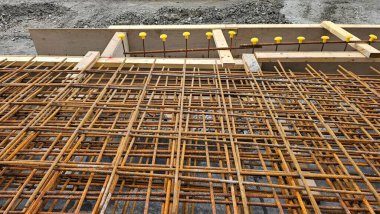 Wooden formwork for pouring concrete from wood for road, piles of steel bars, road red and white cones. Scotland.Works in the city of Aberdeen.High quality photo