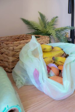 Mutfak tezgahındaki biyolojik poşetteki açık gıda atığının yukarıdan aşağı görüntüsü..