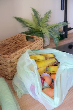 Mutfak tezgahındaki biyolojik poşetteki açık gıda atığının yukarıdan aşağı görüntüsü..