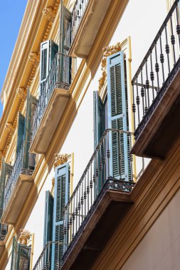 Malaga İspanya 8 Nisan 2025 Tahta pencereli demir balkonlar Eski bir apartmanın dış cephesi. Yüksek kalite fotoğraf