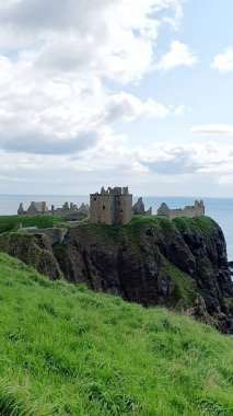 DUNNOTTAR Şatosu, SCOTLAND, BİRLİK KINGDOM, 15.09.2023: Kuzey Denizi kıyısındaki kayalık bir burundaki yıkık ortaçağ kalesi Dunnottar Şatosu. İskoçya 'daki sarp okyanus kayalıklarının tepesinde görkemli bir kale..