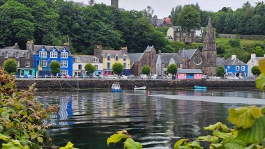 Tobermory, İskoçya 16 Haziran 2024 Tobermory rıhtımındaki renkli evler görülüyor. Dalgalar çekildi. Gri Gök. Yüksek kalite fotoğraf