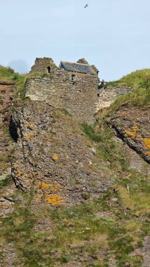 Deniz kenarından manzara. DUNNOTTAR Şatosu, SCOTLAND Kuzey Denizi kıyısındaki kayalık bir burunda bulunan ortaçağ kalesi Dunnottar Kalesi 'ni harap etti. İskoçya 'daki sarp okyanus kayalıklarının tepesinde görkemli bir kale..