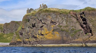 Deniz kenarından manzara. DUNNOTTAR Şatosu, SCOTLAND Kuzey Denizi kıyısındaki kayalık bir burunda bulunan ortaçağ kalesi Dunnottar Kalesi 'ni harap etti. İskoçya 'daki sarp okyanus kayalıklarının tepesinde görkemli bir kale..
