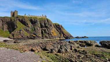 Deniz kenarından manzara. DUNNOTTAR Şatosu, SCOTLAND Kuzey Denizi kıyısındaki kayalık bir burunda bulunan ortaçağ kalesi Dunnottar Kalesi 'ni harap etti. İskoçya 'daki sarp okyanus kayalıklarının tepesinde görkemli bir kale..