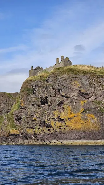 Deniz kenarından manzara. DUNNOTTAR Şatosu, SCOTLAND Kuzey Denizi kıyısındaki kayalık bir burunda bulunan ortaçağ kalesi Dunnottar Kalesi 'ni harap etti. İskoçya 'daki sarp okyanus kayalıklarının tepesinde görkemli bir kale..