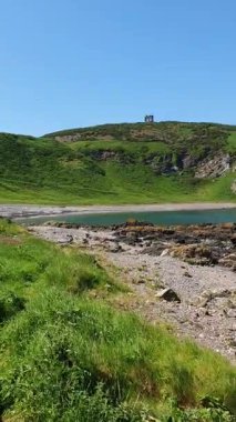 Sersemletici FHD panoramik İskoçya Kuzey Denizi manzarası kıyıdan yarım daire şeklinde bir tarama yakaladı. Gök mavisi su gelgit havuzları ve deniz dokularını vurguluyor. Doğa, jeoloji seyahati ve çevresel temalar için ideal.