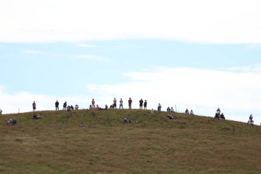 Aberdeen halkı, uzun gemilerin Aberdeen Limanı 'ndan ayrılışını sessizce seyrediyor. Huzurlu bir veda sahnesi, Uzun Gemiler Festivali 'nin son gününde, insanlar kayalık duvarda çimlerin üzerinde otururken,