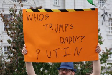 Adamın biri elinde turuncu protesto tabelası tutuyor ve 