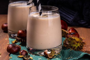 Kestane likörü. Baharatlı baharatlı kremalı içecek çırpılmış kestane, tarçın, baharat, ahşap kırsal arka planda fotokopi alanı.