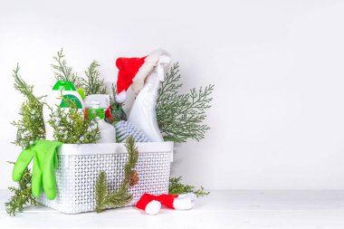 Noel temizliği, kış temizliği kampanyası için reklam afişi. Çeşitli deterjan, şişe, sprey, aksesuar, çatal bıçak, Xmas ağaç dalları ve dekoru olan beyaz ahşap zemin