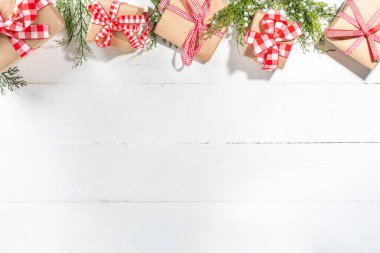  Beyaz ahşap zemin üzerine paketlenmiş Noel hediyesi kutuları, köknar ağacı dalları, üst görünüm kopyalama alanı