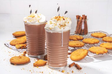 Snickerdoodle milkshake, protein shake or smoothie. Autumn cocoa cookie drink with snickerdoodle scones crumble, whipped cream and cinnamon spicees, white background copy space clipart