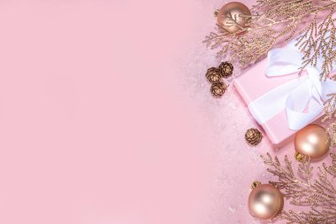 Gül sarısı Noel, yeni yıl arkaplanı altın noel ağacı dalları ve topları, bayram hediyesi kutuları, süslemeler, sanatsal kar, pembe arka plan üzerinde düz yatış fotokopi alanı