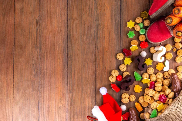 シンタクラース 聖ニコラス日の背景 ニンジンとお菓子の小さな子供の赤い靴 Trooigoo Pepernoten キャンディー オランダのクリスマス休暇の挨拶カード木の背景 — ストック写真