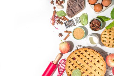 Sonbahar pastası ve kek pişirme arka planı. Tatlı elma, ceviz, kabak kabağı turtaları fırın malzemeleri ve çatal bıçakları, beyaz masa arkaplanı fotokopi alanı
