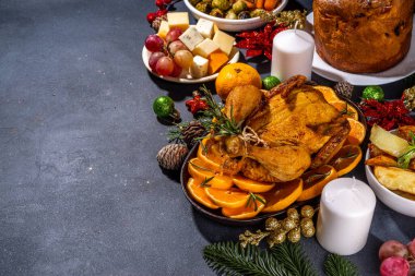 Noel ya da Yeni Yıl yemeği karanlık masada. Geleneksel Xmas parti yemekleri - pannetone, fırında tavuk, sebze, patates, peynir ve meyve tabağı, üst görünüm fotokopi alanı
