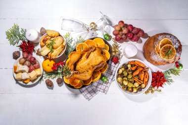 Noel ya da yeni yıl yemeği beyaz ahşap masada. Geleneksel Xmas parti yemekleri - pannetone, fırında tavuk, sebze, patates, peynir ve meyve tabağı, üst görünüm fotokopi alanı