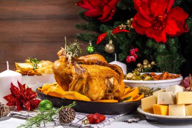 Noel ya da yeni yıl yemeği beyaz ahşap masada. Geleneksel Xmas parti yemekleri - pannetone, fırında tavuk, sebze, patates, peynir ve meyve tabağı, üst görünüm fotokopi alanı