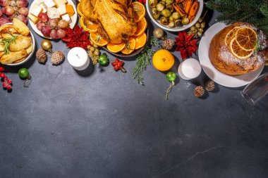 Noel ya da Yeni Yıl yemeği karanlık masada. Geleneksel Xmas parti yemekleri - pannetone, fırında tavuk, sebze, patates, peynir ve meyve tabağı, üst görünüm fotokopi alanı