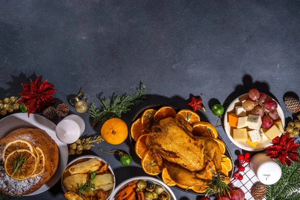 暗いテーブルの上のクリスマスや新年のディナーフード 伝統的なクリスマスパーティー料理のセット パンネ 焼きチキン ポテト チーズ フルーツプレート トップビューコピースペース — ストック写真