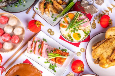 Geleneksel Çin Yeni Yıl yemeği masası, parti davetiyesi, menü geçmişi domuz eti, kızarmış balık, tavuk, pirinç köftesi, mantı, fal kurabiyesi, nian gao keki, erişte, Çin dekorasyonu.
