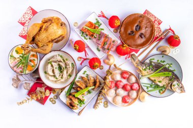 Geleneksel Çin Yeni Yıl yemeği masası, parti davetiyesi, menü geçmişi domuz eti, kızarmış balık, tavuk, pirinç köftesi, mantı, fal kurabiyesi, nian gao keki, erişte, Çin dekorasyonu.