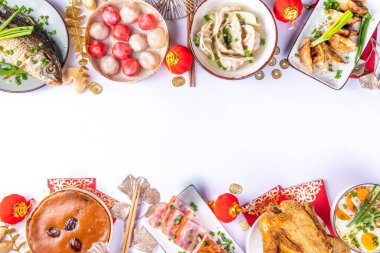 Geleneksel Çin Yeni Yıl yemeği masası, parti davetiyesi, menü geçmişi domuz eti, kızarmış balık, tavuk, pirinç köftesi, mantı, fal kurabiyesi, nian gao keki, erişte, Çin dekorasyonu.