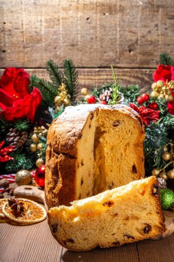 Geleneksel Noel panettone pastası. Kurumuş meyveler, baharatlar, Noel ağacı ve kırsal ahşap arka planda süslemeler. 