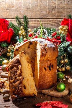 Geleneksel Noel panettone pastası. Kurumuş meyveler, baharatlar, Noel ağacı ve kırsal ahşap arka planda süslemeler. 