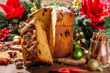 Geleneksel Noel panettone pastası. Kurumuş meyveler, baharatlar, Noel ağacı ve kırsal ahşap arka planda süslemeler. 