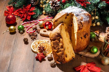 Geleneksel Noel panettone pastası. Kurumuş meyveler, baharatlar, Noel ağacı ve kırsal ahşap arka planda süslemeler. 