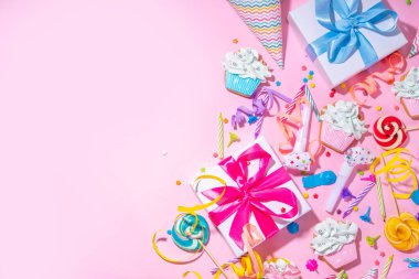 Mutlu yıllar tebrik kartı geçmişi. Renkli tatil aletleri olan düz yatak - doğum günü partisi şapkaları, şişirme makineleri, hediye kutuları, balonlar, buharlı mumlar, pembe arka plan fotokopi alanı