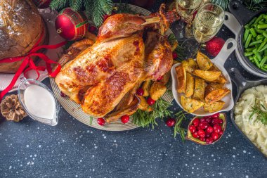 Noel ya da yeni yıl hindi yemeği. Fırında hindi, patates, kırmızı böğürtlen ve adaçayı, Noel yemeği masasında Noel ağacı, hediye ve mum.