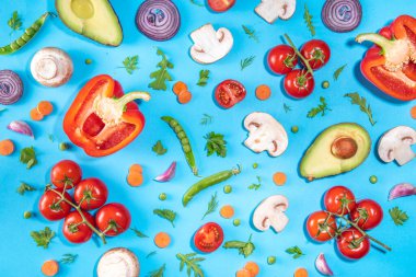 Çeşitli taze sebzeler. Çiğ organik sebzeler, salata malzemeleri canlı mavi arka planda parlak düz bir döşeme. Sağlıklı beslenme, vejetaryen vejetaryen yemek pişirme arka plan fotokopi alanı