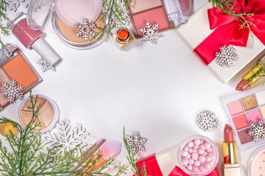 Kış ve Noel dekoratif makyaj malzemeleri, yapay kar taneleri, Noel ağacı dalları, hediye kutuları, güzellik aksesuarları. Noel ve Yeni Yıl kış kozmetik ürünleri satışı bembeyaz arka planda duruyordu
