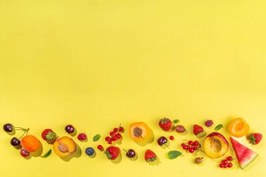 Yaz vitamini yiyeceği konsepti, çeşitli meyve ve meyveler karpuz şeftali, şeftali, nane aromalı kayısı böğürtlen üzümü üzümü üzümü üzümü, kreatif düz sarı zemin üzerinde yatar.