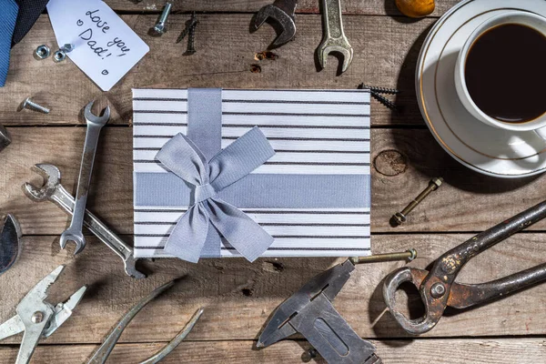 Babalar Günü tebrik kartı geçmişi. Babalar günü konsepti hediye kutusu, aletler ve kravatlar, kahve fincanı, hediye etiketi, baban seni seviyor, kırsal ahşap arka planda fotokopi odası
