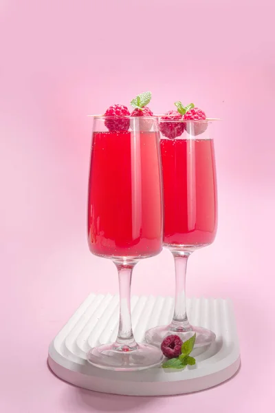 Red mimosas cocktail. Classic mimosa drink with raspberry juice, raspberry and mint decor. Summer bar menu concept, copy space