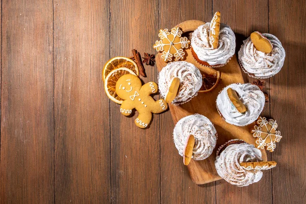 クリスマスのジンジャーブレッドカップケーキ ホイップクリーム 冬のスパイスとジンジャーブレッドクッキーの装飾と甘いチョコレートと白いマフィンカップケーキ 木製の居心地の良い背景コピースペース — ストック写真