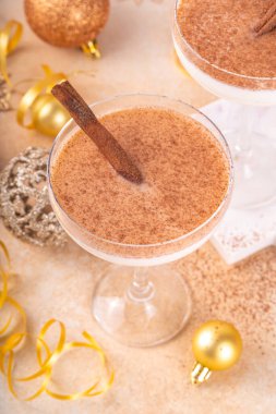 Tarçın ve hindistan cevizli eggnog martini kokteyli, altın Noel süslemeleri ve bokeh efekti, boşluğu kopyala