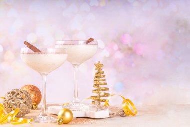 Tarçın ve hindistan cevizli eggnog martini kokteyli, altın Noel süslemeleri ve bokeh efekti, boşluğu kopyala