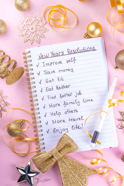 Notebook with New\'s Year Resolutions massage, with Christmas ornaments and decor. New Year goals List 2023, plan listing of new year beginnings goals and resolutions setting. Flat lay copy space