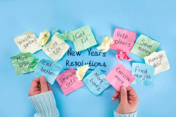 New year goals or resolutions on bright colorful paper stickers. New Year goals List 2023, plan listing of new year beginnings goals and resolutions setting. Flat lay copy space on blue background