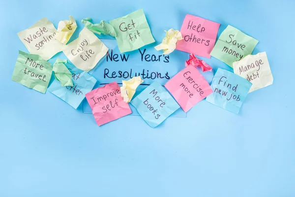 New year goals or resolutions on bright colorful paper stickers. New Year goals List 2023, plan listing of new year beginnings goals and resolutions setting. Flat lay copy space on blue background