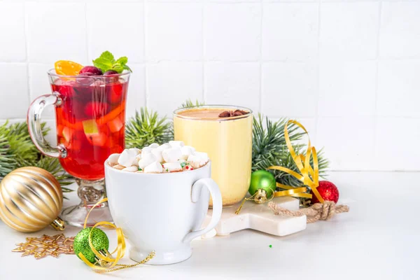 Set of traditional Christmas winter drinks. Christmas bar menu background.Tree cup with mulled wine, eggnog, hot chocolate beverages om white table with Christmas, New Year decorations, copy space.