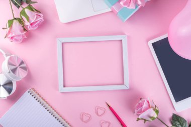 Romantik tatil geçmişi. 8 Mart Kadınlar Günü, Sevgililer Günü hazırlığı dizüstü bilgisayarı, pembe güller buketi, hediye kutusu, not defteri, kazak, başlık, şirin pembe arka plan fotokopi alanı