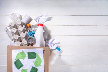 Çöp ayıklama, atık geri dönüşüm konsepti. Geri dönüşüm malzemelerinin olduğu kutu - plastik, cam, kağıt, karton, beyaz ahşap arka plan fotokopi alanı. Kadın elleri çeşitli çöp ve çöpleri ayırıyor.