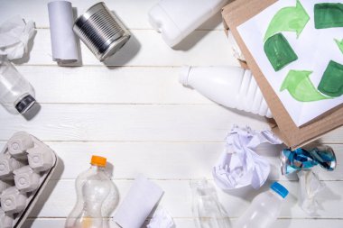 Çöp ayıklama, atık geri dönüşüm konsepti. Geri dönüşüm malzemelerinin olduğu kutu - plastik, cam, kağıt, karton, beyaz ahşap arka plan fotokopi alanı. Kadın elleri çeşitli çöp ve çöpleri ayırıyor.